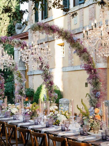Romantic pastel wedding centerpiece with layered glassware and elegant table styling in Tuscany