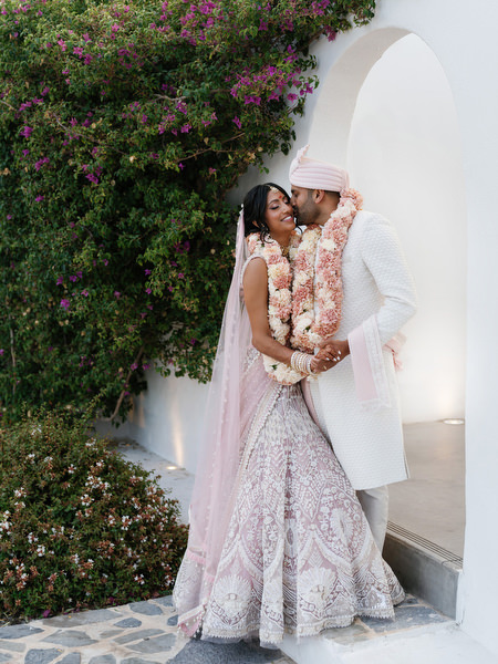 Romantic couple portrait beneath white Mediterranean arch at Island Resort the Residence