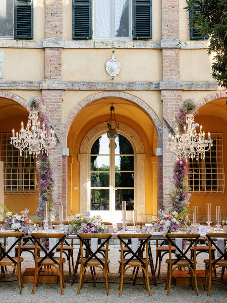 Reception tables arranged in front of historic La Foce villa façade in Tuscany