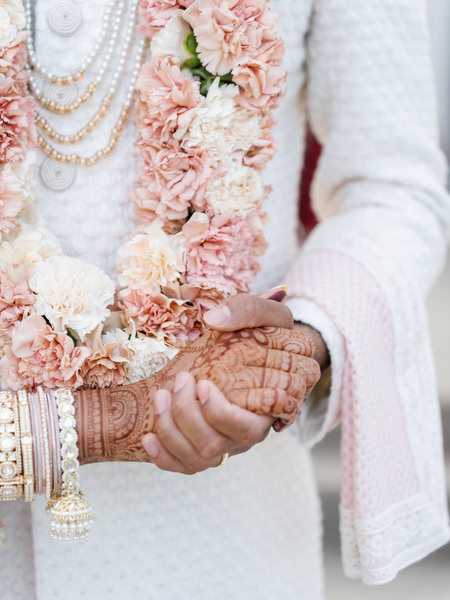 Close-up of floral garlands and henna hands during the Hindu ceremony at Island Resort the Residence