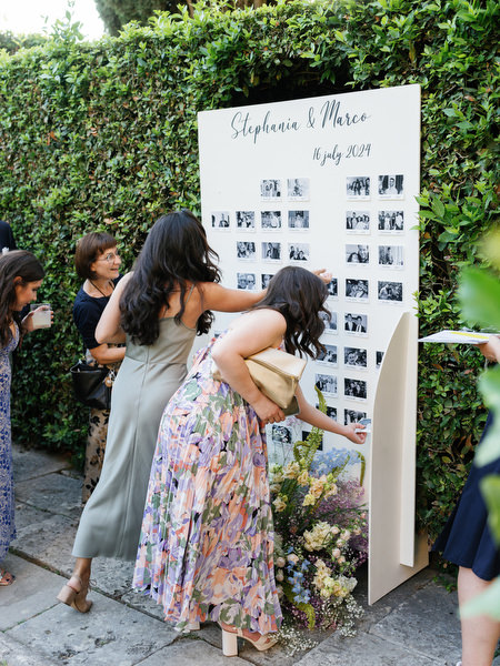 Guests viewing wedding seating chart during cocktail hour at La Foce in Tuscany