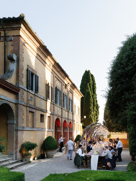 Guests gathering for outdoor wedding reception in the gardens of La Foce estate