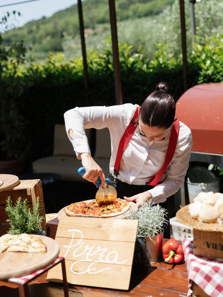 Wood-fired pizza being prepared at Tuscany wedding pool party