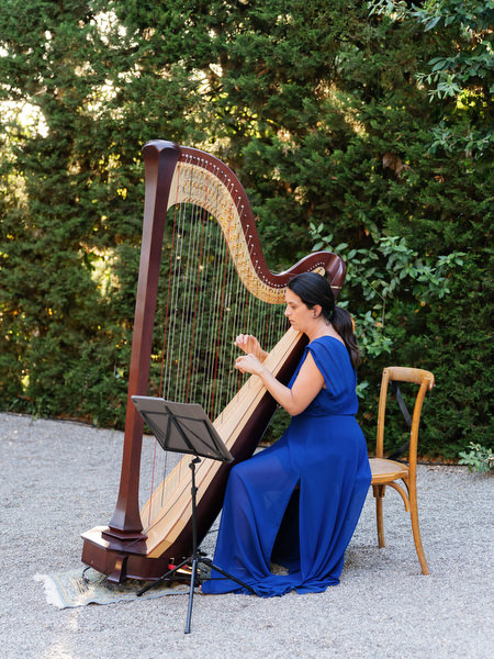 Live harpist performing during elegant Tuscany destination wedding reception