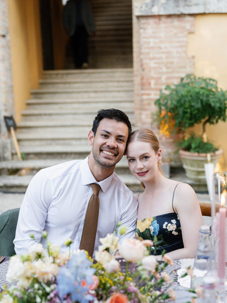 Wedding guests seated at elegantly styled reception table during al fresco dinner in Tuscany