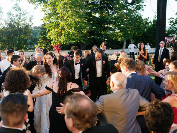 Guests dancing in a circle during Jewish hora at Villa Corsini a Mezzomonte, Florence Tuscany wedding reception.