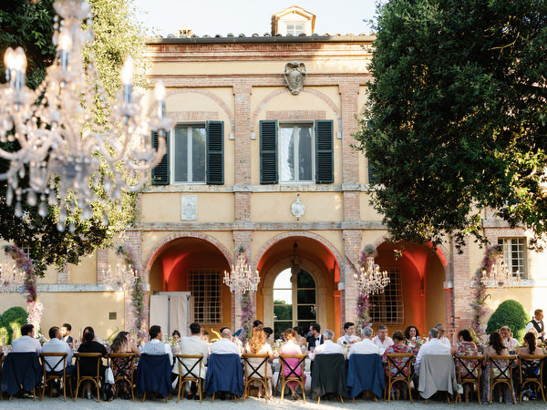 Outdoor wedding dinner set in the courtyard of La Foce estate in Tuscany