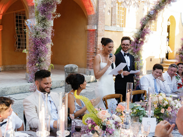 Bride giving heartfelt speech during candlelit luxury wedding reception in Tuscany