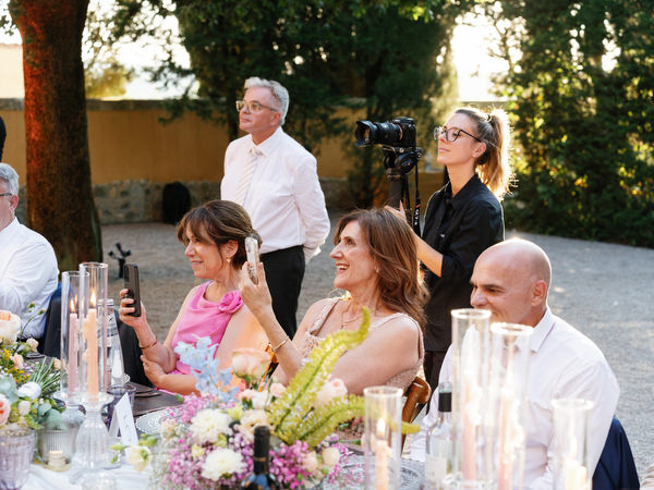 Guest laughing during joyful al fresco wedding reception in Tuscany