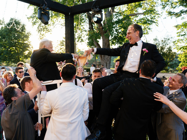 Fathers lifted on chair during Jewish wedding reception at Villa Corsini a Mezzomonte, Florence.