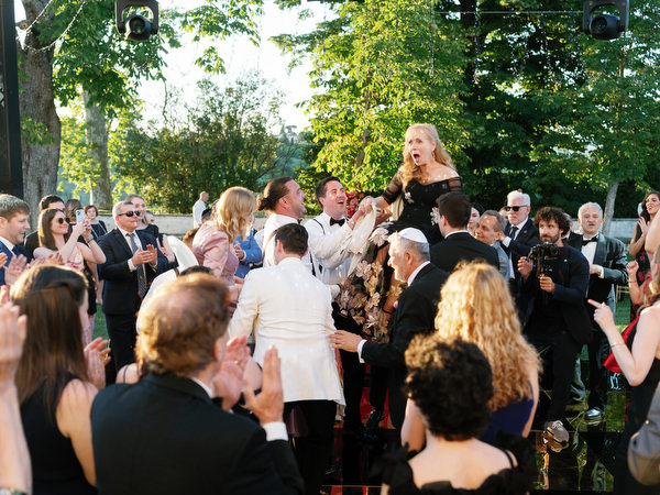 Mother raised on chair during Jewish hora celebration at Villa Corsini Tuscany wedding.