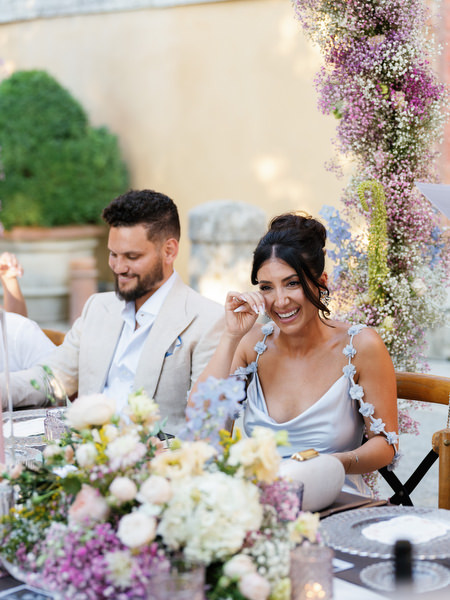 Emotional guest wiping away tears during intimate wedding dinner in Tuscany