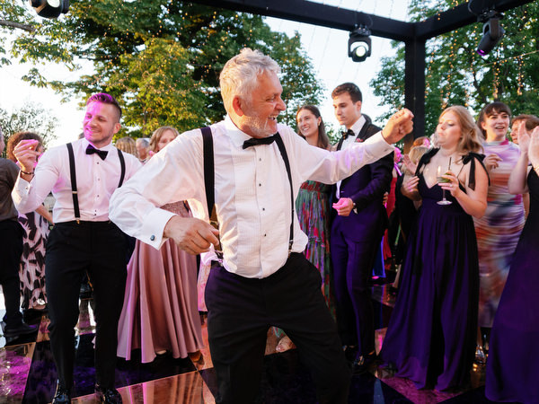 Wedding guest dancing energetically during Jewish hora at Villa Corsini Tuscany.