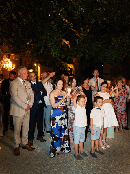 Wedding guests applauding during elegant evening celebration in Tuscan villa courtyard