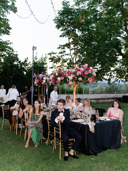 Wedding guests seated at floral reception tables at Villa Corsini a Mezzomonte in Tuscany.