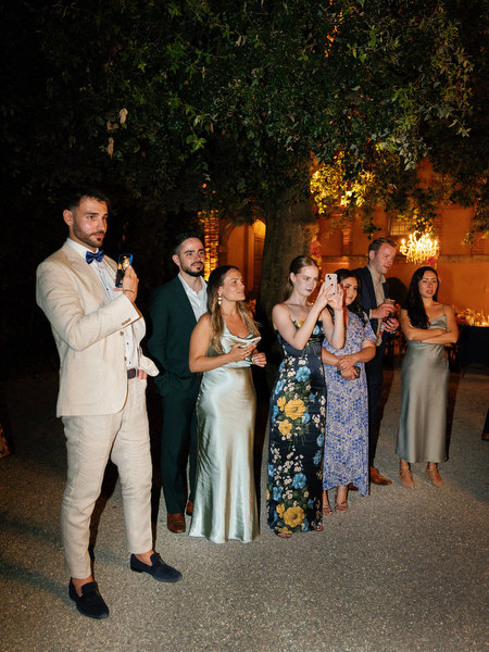 Wedding guests gathered for evening cake cutting celebration at La Foce estate in Tuscany