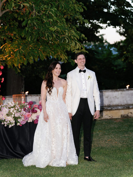Bride and groom standing together during sunset reception at Villa Corsini Tuscany wedding.