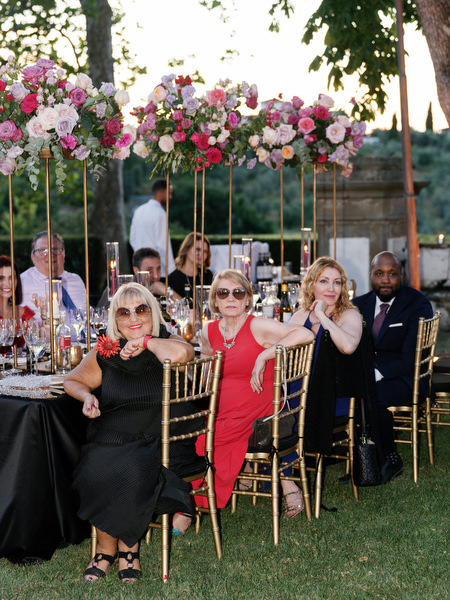 Guests listening during reception under pink floral centerpieces at Villa Corsini Florence.