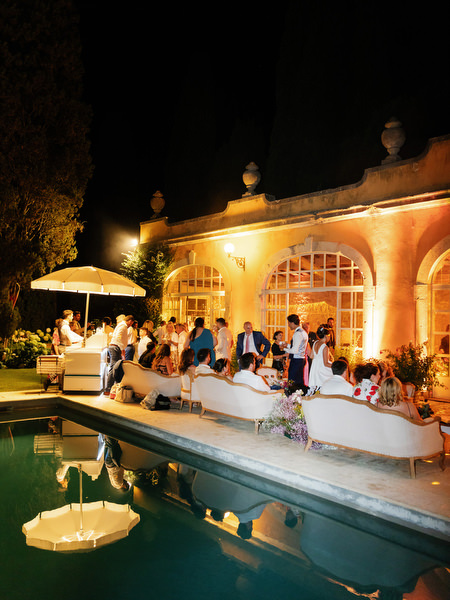 Black and white candid of guests walking through illuminated garden at night