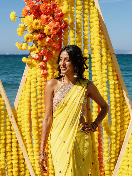Bride smiling during Haldi ceremony with yellow decor