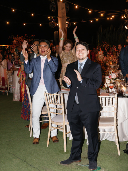 Guests clapping and celebrating under string lights at Island Resort the Residence