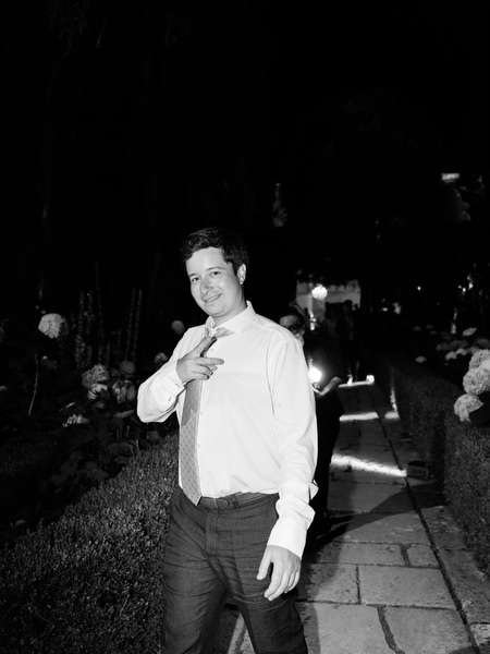 Stylish wedding guest posing during evening celebration in Italian villa courtyard