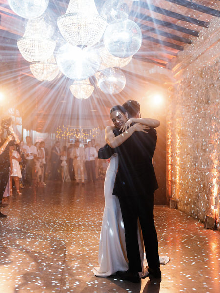 Romantic embrace during first dance at elegant Italian estate reception