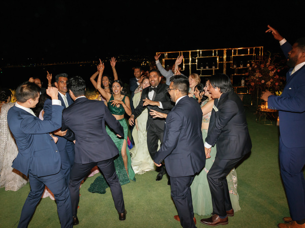 Group of friends dancing on reception lawn at Island Resort the Residence