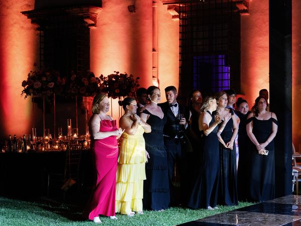 Wedding party watching first dance at Villa Corsini Tuscany evening reception.