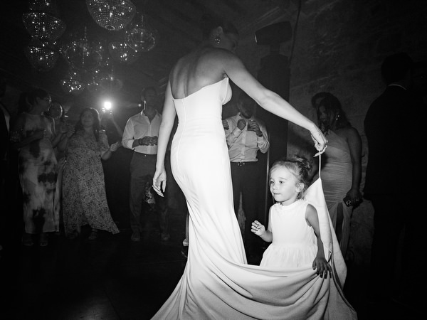 Bride dancing with young guest on lively wedding dance floor in Italy