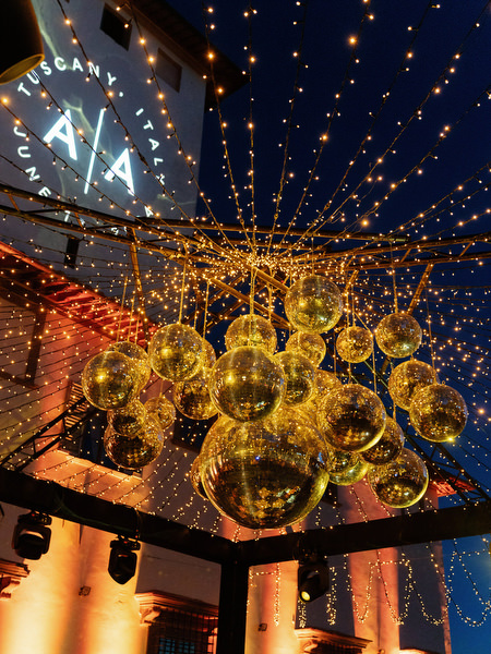 Golden disco balls and string lights at Villa Corsini Tuscany wedding reception.
