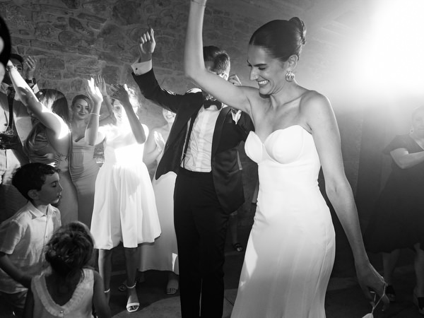 Bride dancing joyfully among guests during unforgettable Tuscany wedding after-party