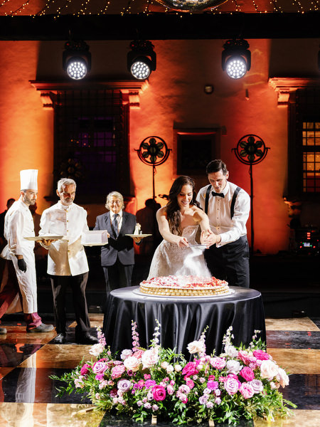 Bride and groom cutting wedding cake during Tuscany villa reception at Villa Corsini.