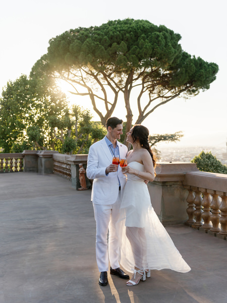 Couple embracing with panoramic Tuscany sunset views