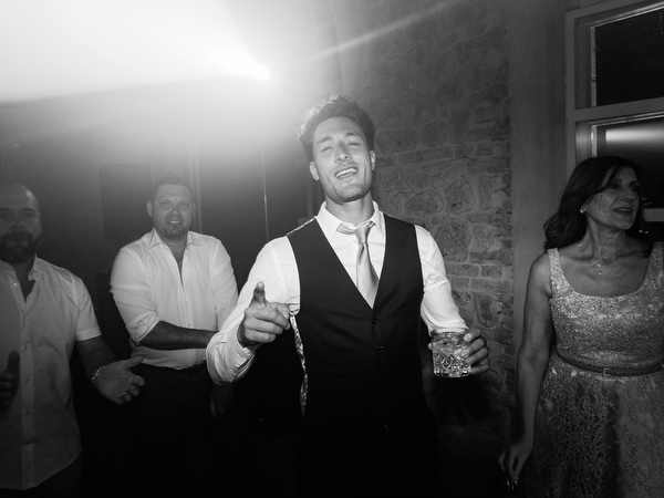 Groomsmen singing and celebrating during late-night wedding party in Tuscany