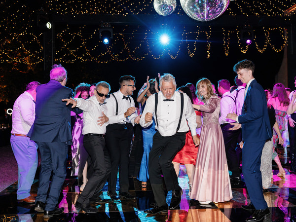 Guests dancing under string lights at Villa Corsini Tuscany wedding party.