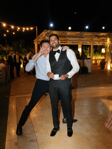 Guests posing and laughing under string lights at Island Resort the Residence on the Athens Riviera