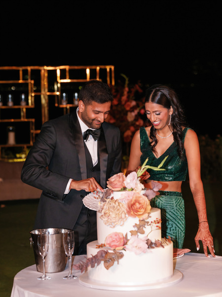 Bride and groom cutting cake at Island Resort the Residence Indian wedding in Athens