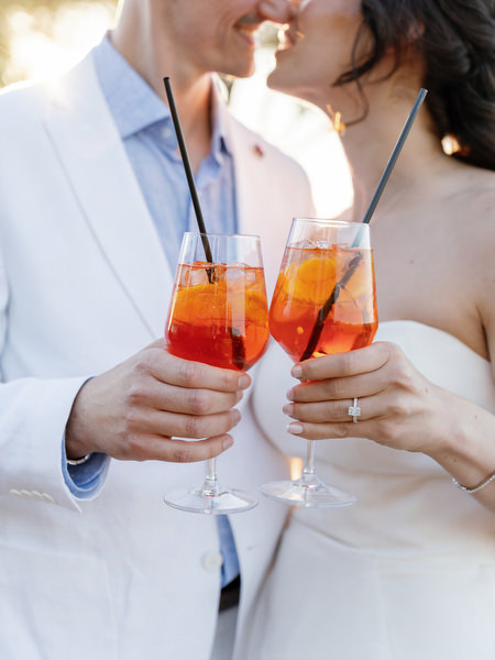 Bride and groom holding Aperol Spritz cocktails during Florence welcome party