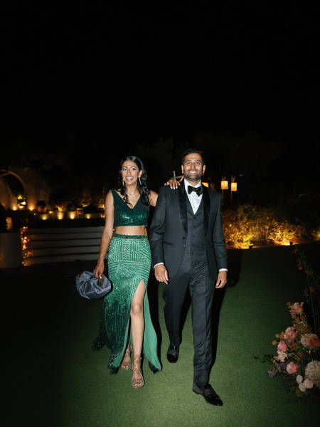 Bride and groom walking together at night reception at Island Resort the Residence overlooking the Athens Riviera