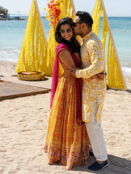 Couple embracing during Haldi ceremony at beach