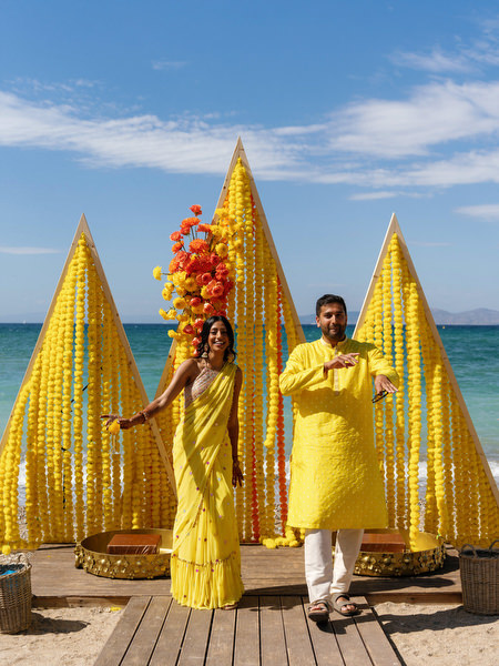 Couple infront of Haldi ceremony beach installation