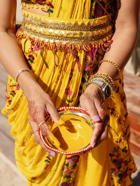 Bride hands holding Haldi turmeric bowl