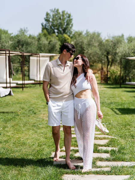 Newlyweds walking through Tuscan garden path