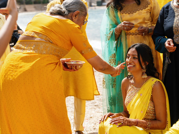 Family members applying turmeric to bride