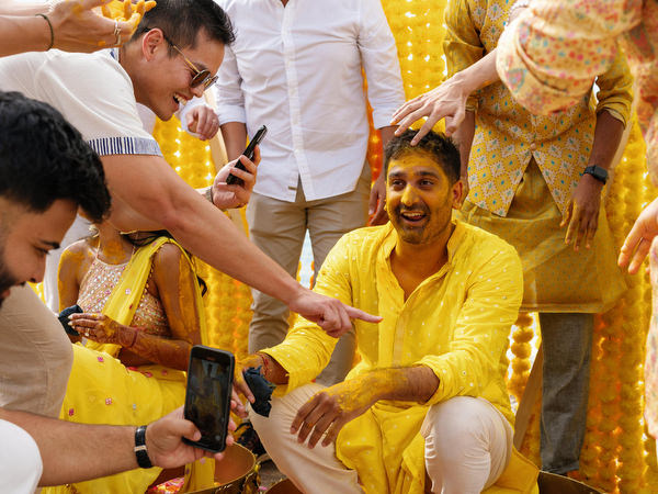 Family members applying turmeric to groom