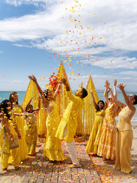 Guests throwing flower petals at Haldi celebration