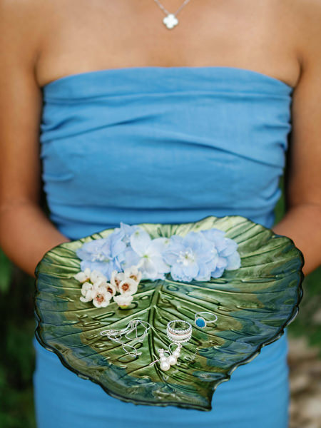 Periwinkle dress detail holding wedding rings and flowers.