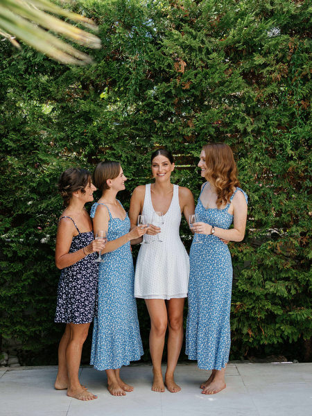 Bridesmaids in blue dresses sharing a toast at Island Resort, Athens Riviera destination wedding in Greece.