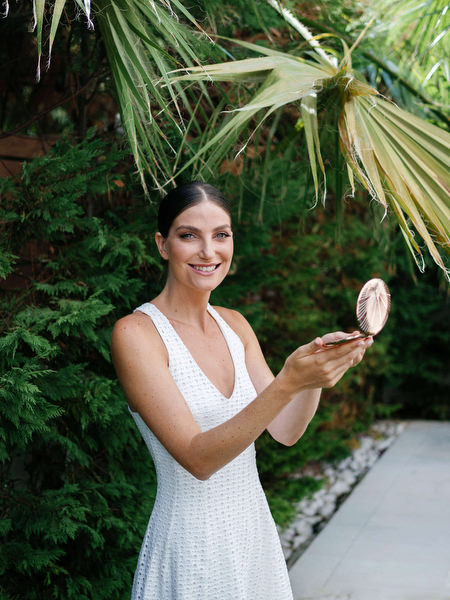 Bride holding a compact mirror during bridal prep at Island Resort, luxury destination wedding in Athens, Greece.
